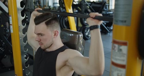 Muscular Athlete Works Out in Modern Gym Making Seated Barbell Shoulder Press