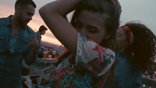 Friends Dancing at Rooftop Party at Sunset