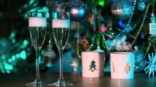 Champagne Glasses Being Filled Near Christmas Tree