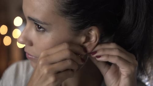 Woman Puts On Shiny Silver Hoop Earring