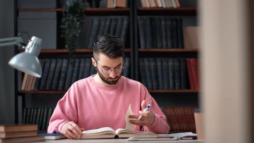 Casual Academic Man Learning Paper Textbook Making Notes Writing Information Working Library Desk