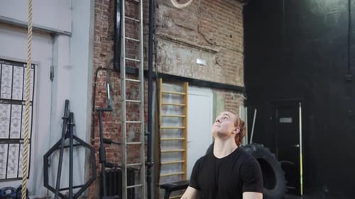 A Strong Sportsman is Jumping and Hanging on Gymnastic Rings