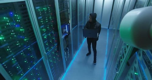 Hacker com laptop na sala do servidor