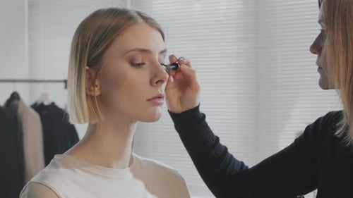 Female Make-Up Artist Putting Mascara on Model