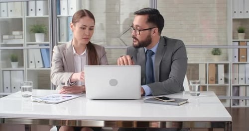 Business Colleagues Working Together on Laptop in Office