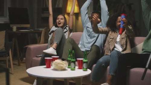 Friends Cheering on Couch During Game Night