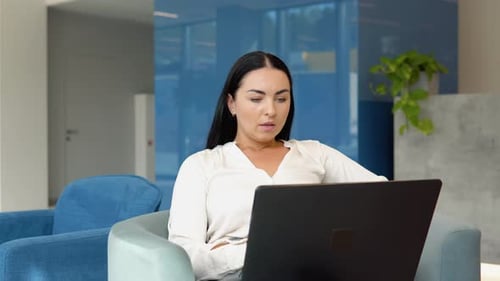 Relaxed Young Adult Working in Modern Office