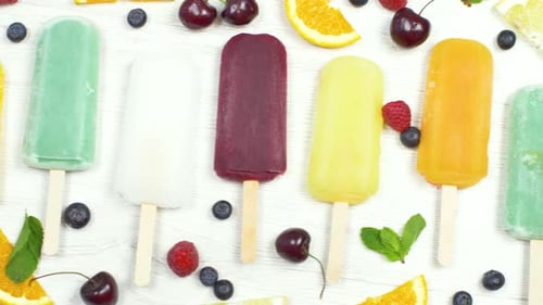Colorful Popsicles on White Wood Table with Fruit