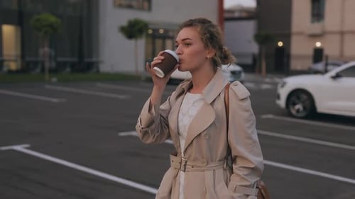 Stylish Woman Walking and Drinking Coffee in City