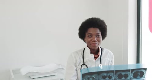 Female AfricanAmerican Doctor Examines XRAY Of Lungs In Clinic