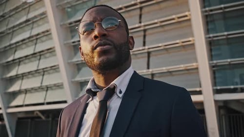 Peaceful African American Businessman Looking Straight Standing Outdoors Near Office Building