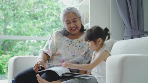 Grandmother and Child Reading a Book Indoors