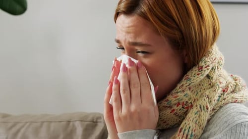 Woman Coughing and Blowing Her Nose With a Tissue
