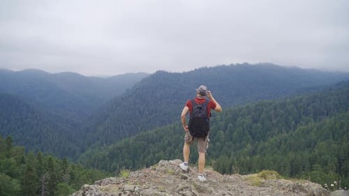 Man Hiking Mountain Trail, Admiring Forest Landscape