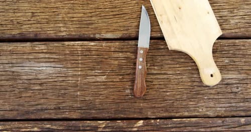 Wooden Table with Knife and Cutting Board