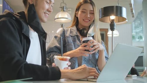 Happy asian couple take off face mask in a coffee shop