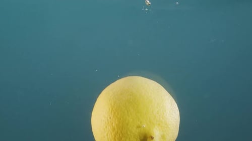 Fresh Lemon Gently Floating in Clear Water