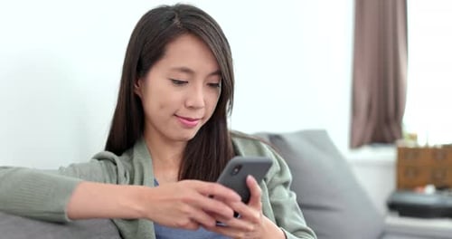 Woman Relaxing and Using Smartphone Indoors