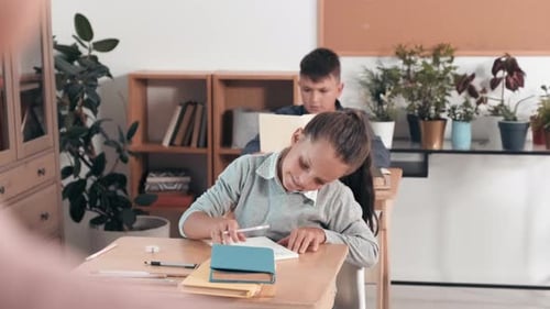 Schulmädchen zeigt Zeichnung im Klassenzimmer