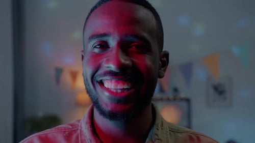 Young Adult Man Smiling in Red and Blue Lights