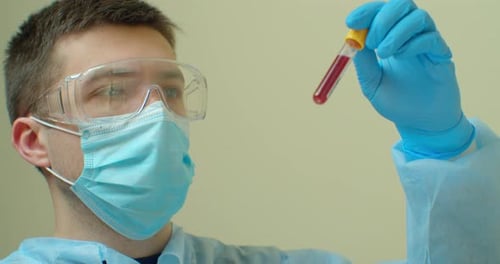Doctor Holding Positive Blood Sample Covid 19, Coronavirus or Sars Covid 19 Test Tube in Hand at