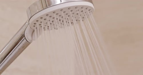 Water Flows from Shower Head in Bathroom