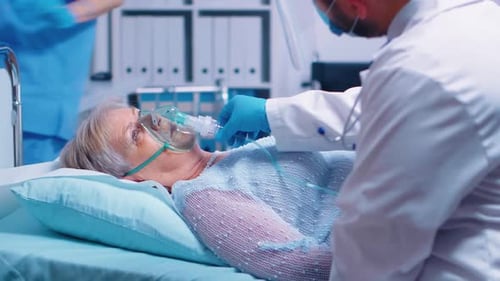 Elderly Woman with Oxygen Mask in Hospital Bed