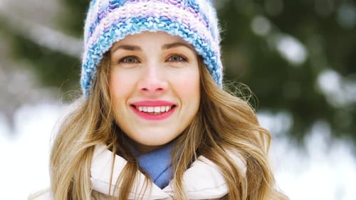 Smiling Woman Wearing Knit Hat in Winter Scene