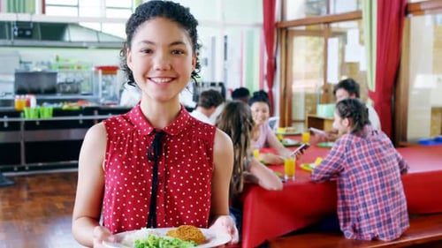 Smiling Teen Holding Lunch Plate in School Cafeteria