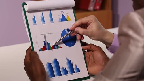 Business Colleagues Review Charts in Office Setting