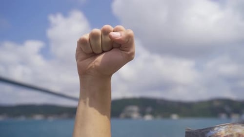 Arm Raised in a Fist Against Sky Background