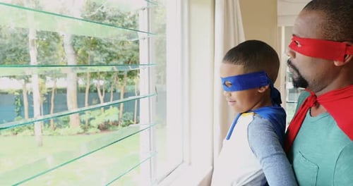 Dad and Boy Superhero Role Playing by Window