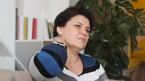 Close Up of the Woman Holding Her Neck Behind As She Having Headache
