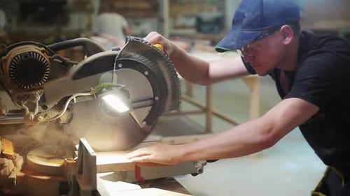 Carpentry Workshop Worker Cutting on the Wooden Desk Using a Big Circular Saw