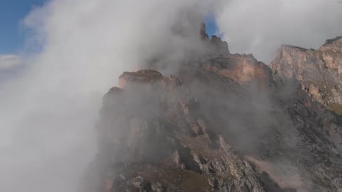 Aerial Shot of Flying Over the Mountain Peaks Among the Clouds
