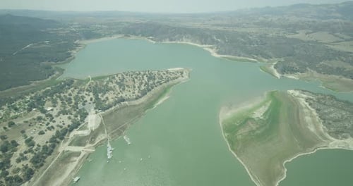 Helicopter aerial shot of yellow and green plants on side of mountain, cloudy day