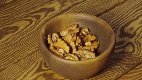 Walnuts Being Poured into a Wooden Bowl