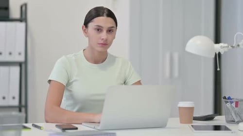 Smiling Woman Works on Laptop in Office