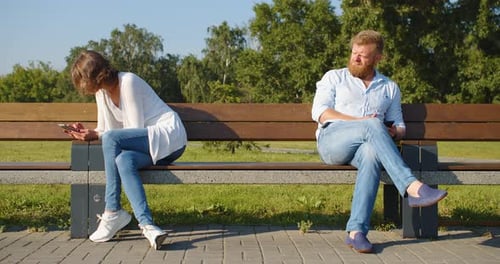 Couple on Bench Using Phones in Park