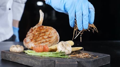 Chef Plating Delicious Grilled Chop with Vegetables