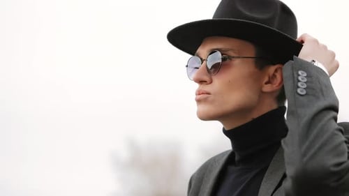 Stylish Young Adult Poses Wearing Hat and Sunglasses