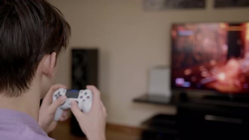 Person Playing Video Game Using Controller at Home