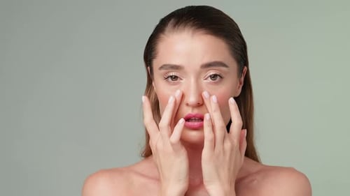 Woman Posing with Makeup Touches Face