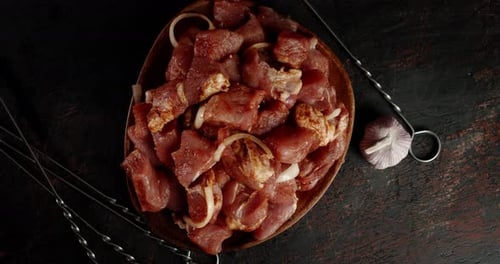 A Plate of Raw Pork Kebab with Spices and Onions Rotates.