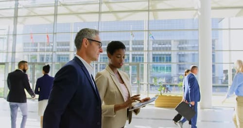 Multi ethnics business people discussing over digital tablet in the office lobby 4k