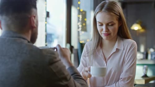 Couple Drinking Coffee in Cozy Cafe