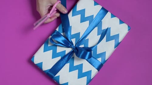 Close Up Shot of the Woman's Hands Are Tying a Bow on the Present Box, Wrapping the Presents in