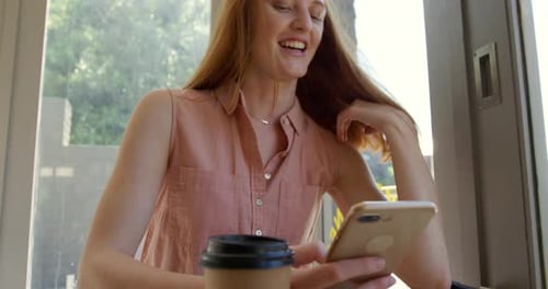 Young woman using smartphone in a cafe