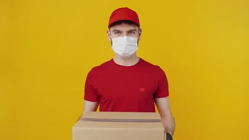 Kurier mit Schutzmaske und Handschuhen bietet Paket an