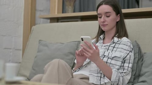 Woman on Couch Using Smartphone Device